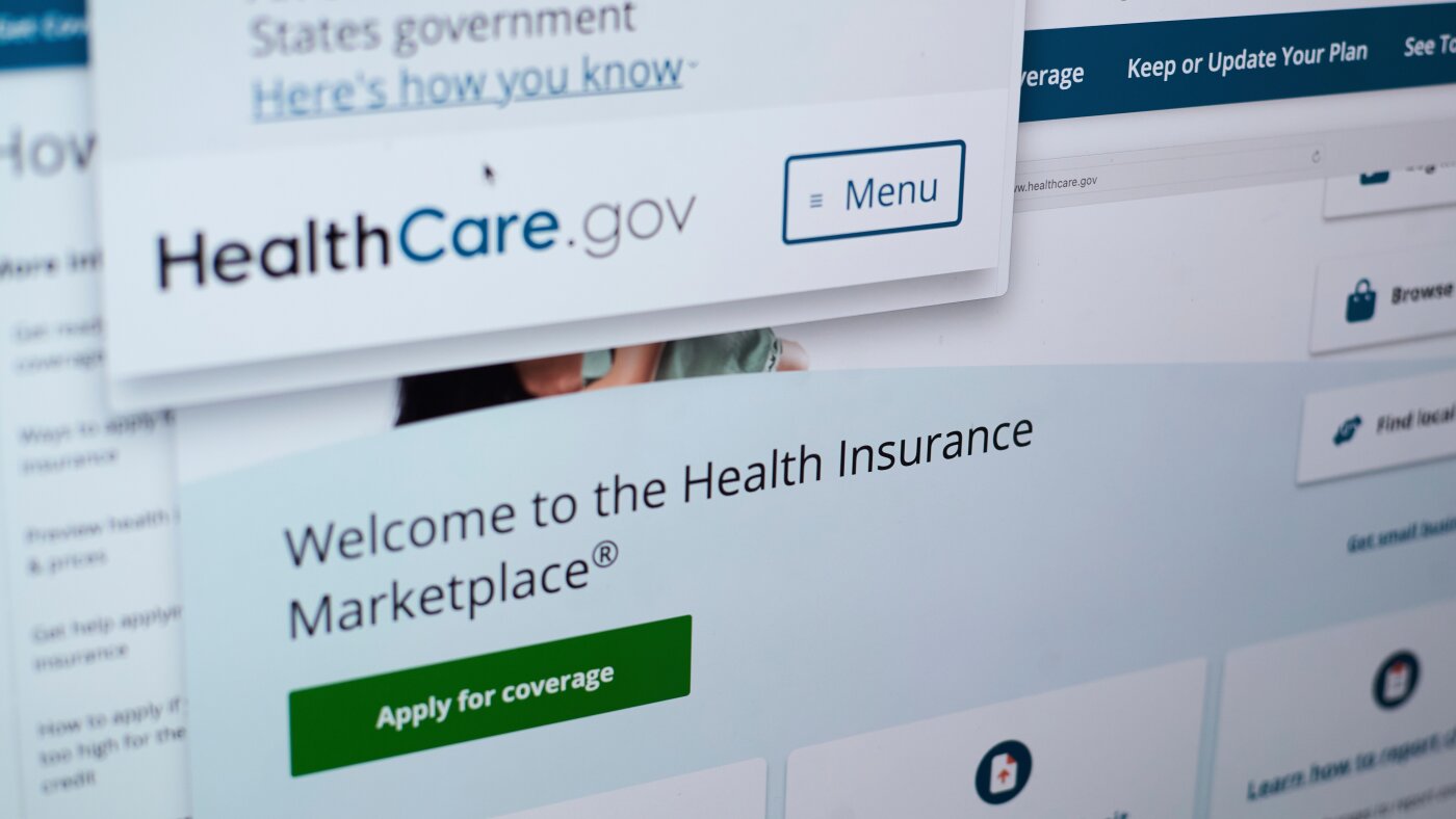 A worried family reviews rising health insurance premium bills at a kitchen table after ACA subsidies expired