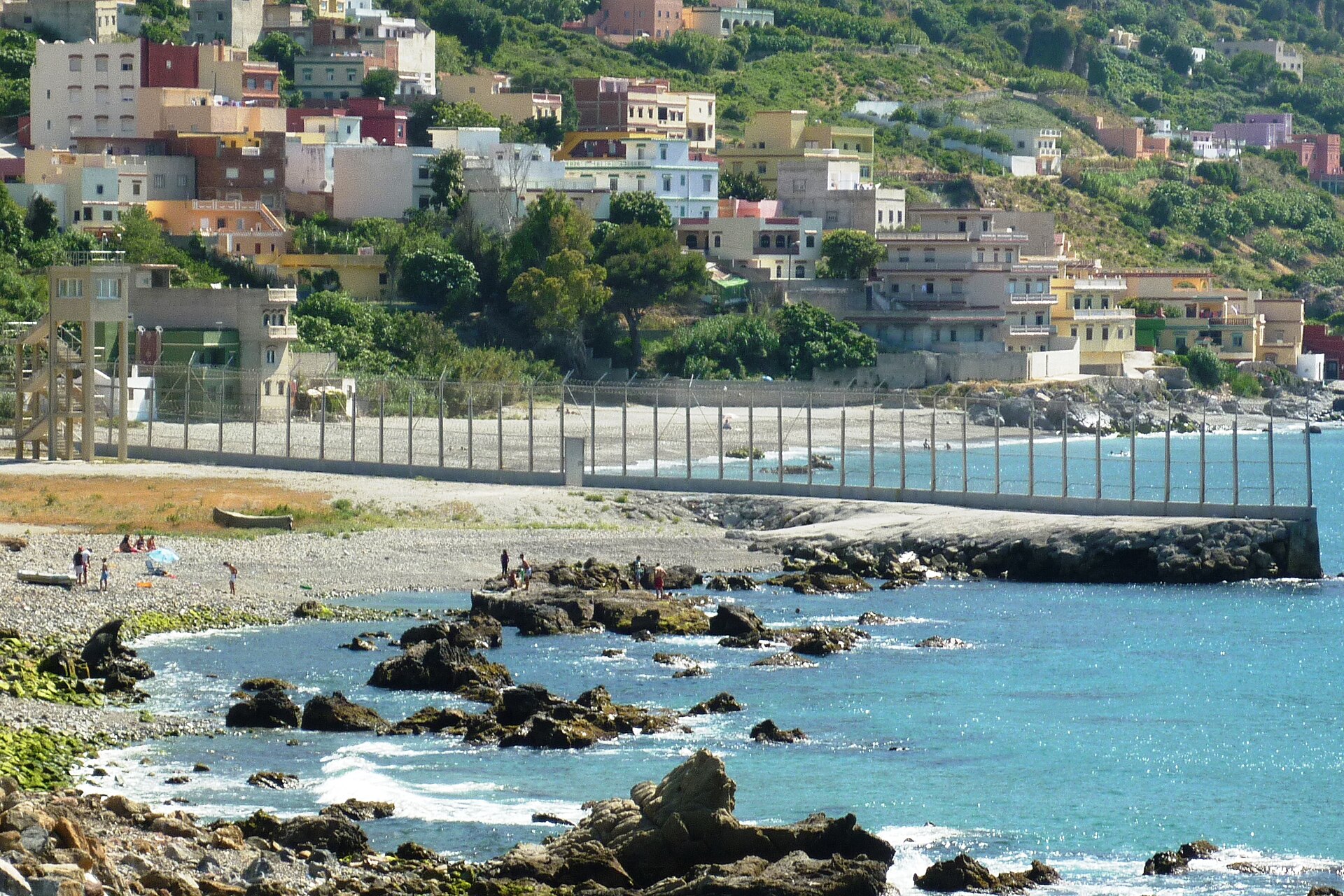 Double border fence separating Ceuta from Morocco, the barrier thousands of migrants bypassed by sea during the July 2026 surge. Photo: Mario Sanchez Bueno / Wikimedia Commons, CC BY-SA 2.0
