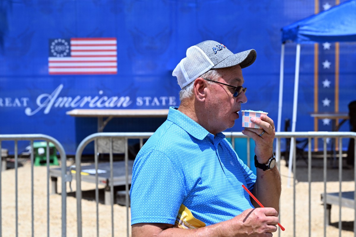 Travelers wait near departure boards inside LaGuardia Airport during a record Northeast heat wave over the July 4 weekend
