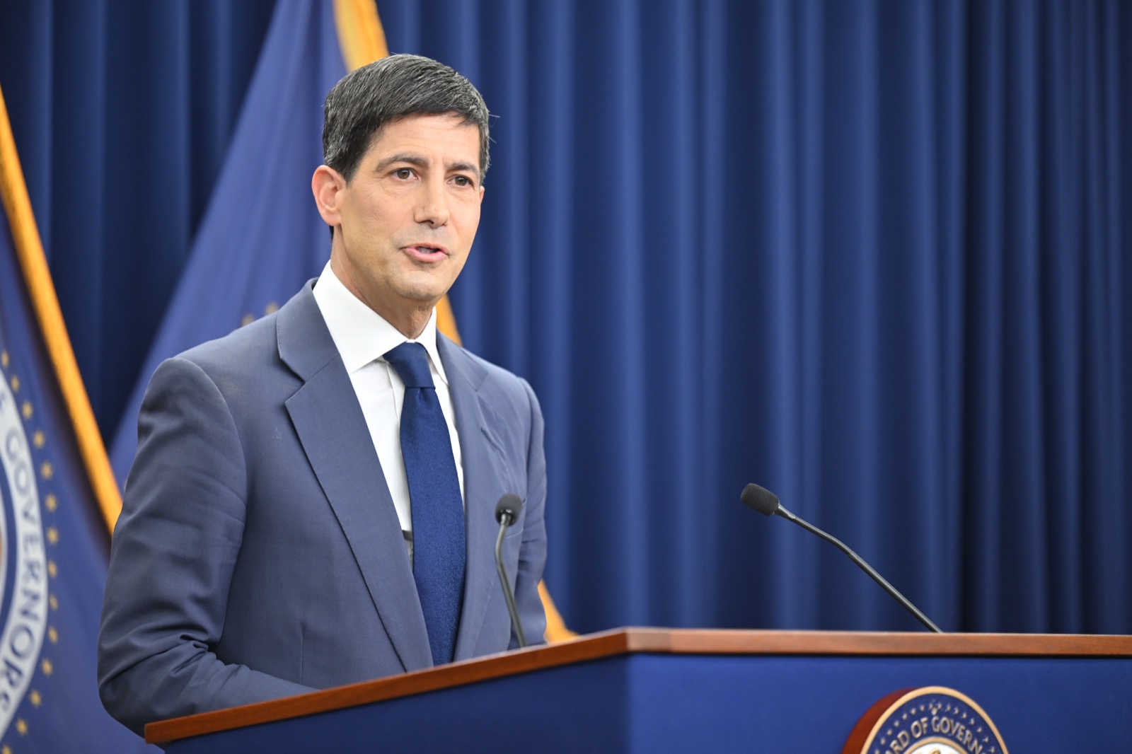 Federal Reserve Chair Kevin Warsh answers reporters' questions at the lectern during the June 2026 FOMC press conference. Photo: Federal Reserve / Wikimedia Commons, Public domain.