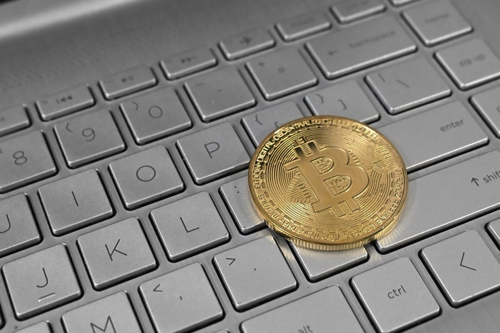 Physical bitcoin token resting on a laptop keyboard. Photo: Satheesh Sankaran, CC BY 2.0