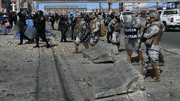Bolivian soldiers and police clear a road blockade during the nationwide state of emergency. Photo: CBC News