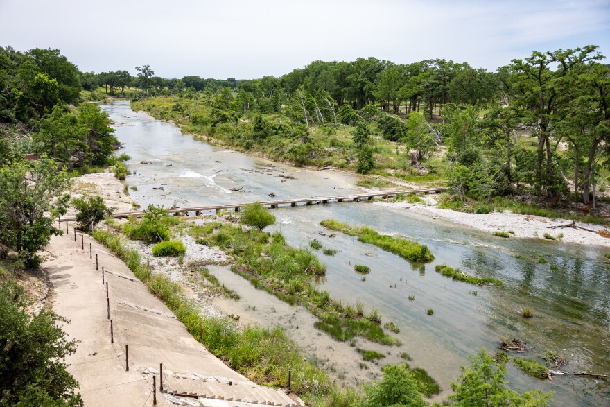 Bent and broken trees along the Guadalupe River in Kerrville, Texas, nearly one year after the July 4 flood. Photo: KUT News