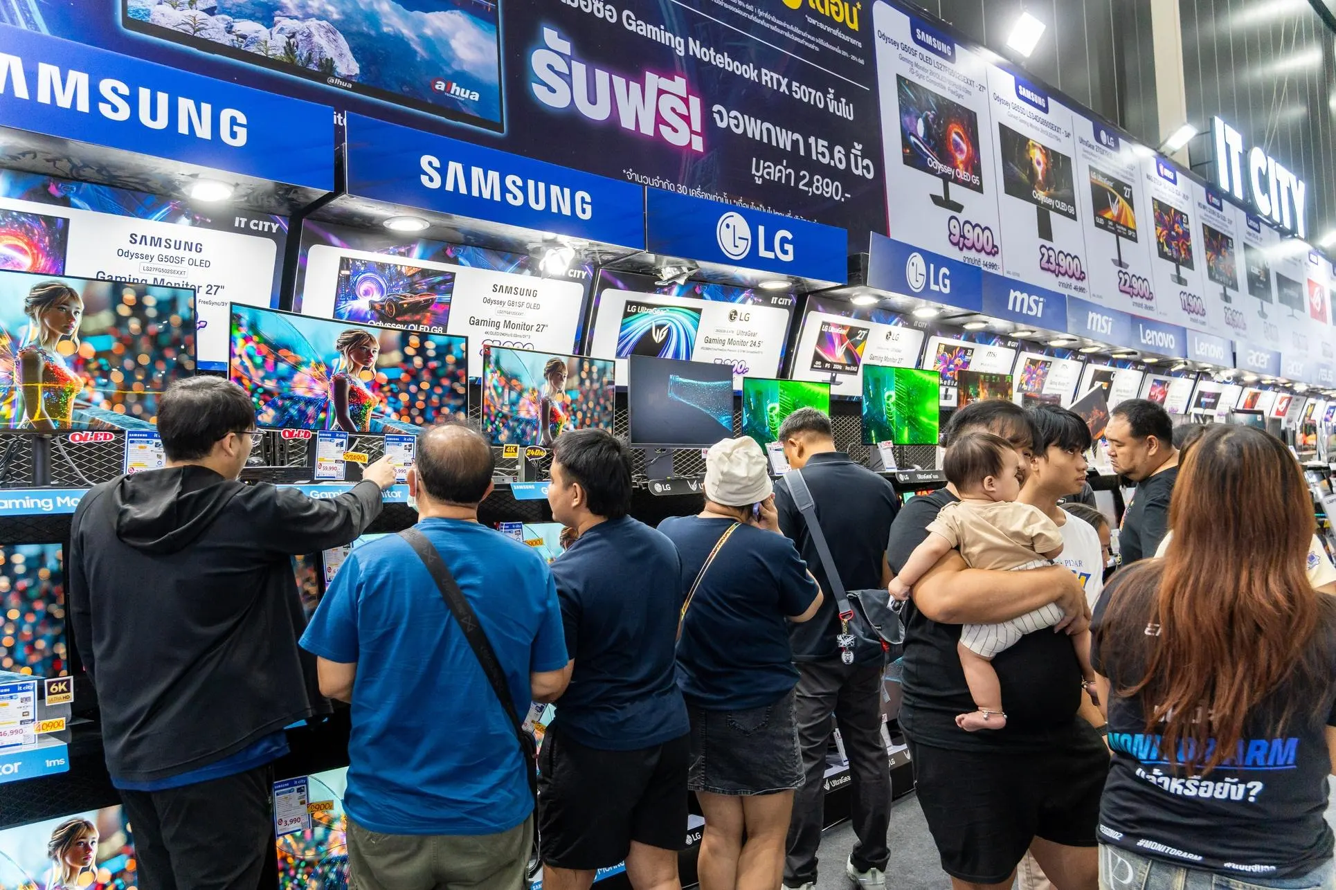 Visitors examine rows of Samsung, LG, Lenovo and MSI monitors at a technology trade show. Photo: Forbes