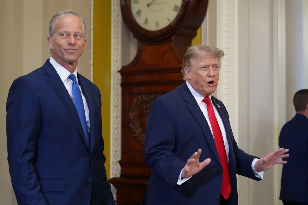 President Trump speaking at a White House podium as coverage of the stalled housing bill signing plays behind him