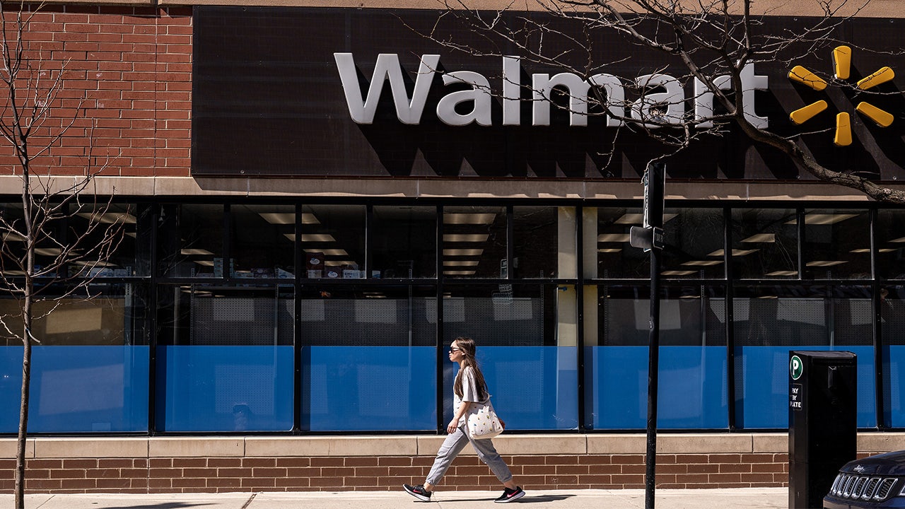 Exterior of a Walmart store with the company logo and signage against a clear sky